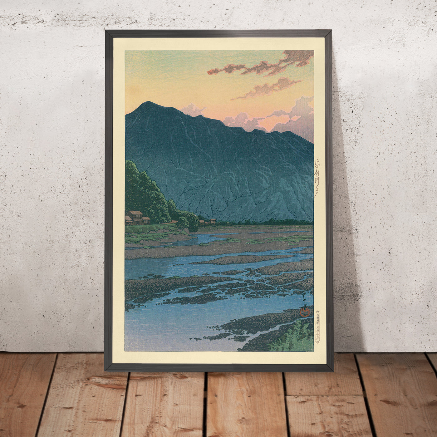 A framed image of Mountain Sunset and Muddy River by Hasui Kawase, 1935